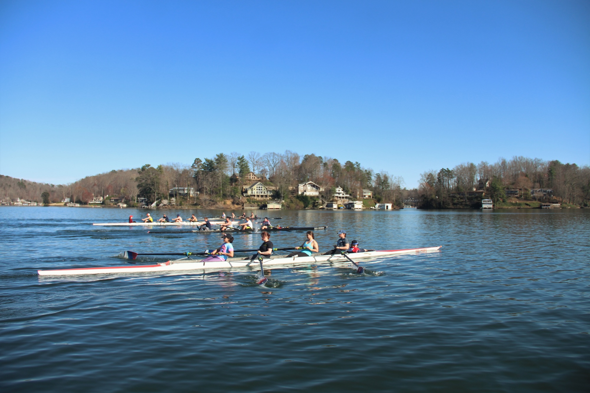 Shot of 4 boats of rowers practicing racing on the water.